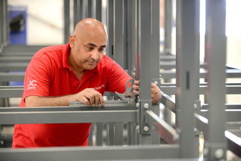 man checking for the precision manufacture and assembly of a metal stand