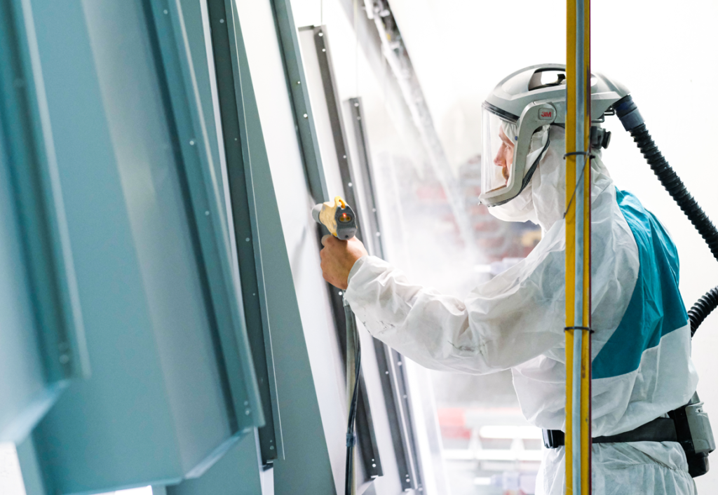 JC Metalworks employee spraying a powder coating